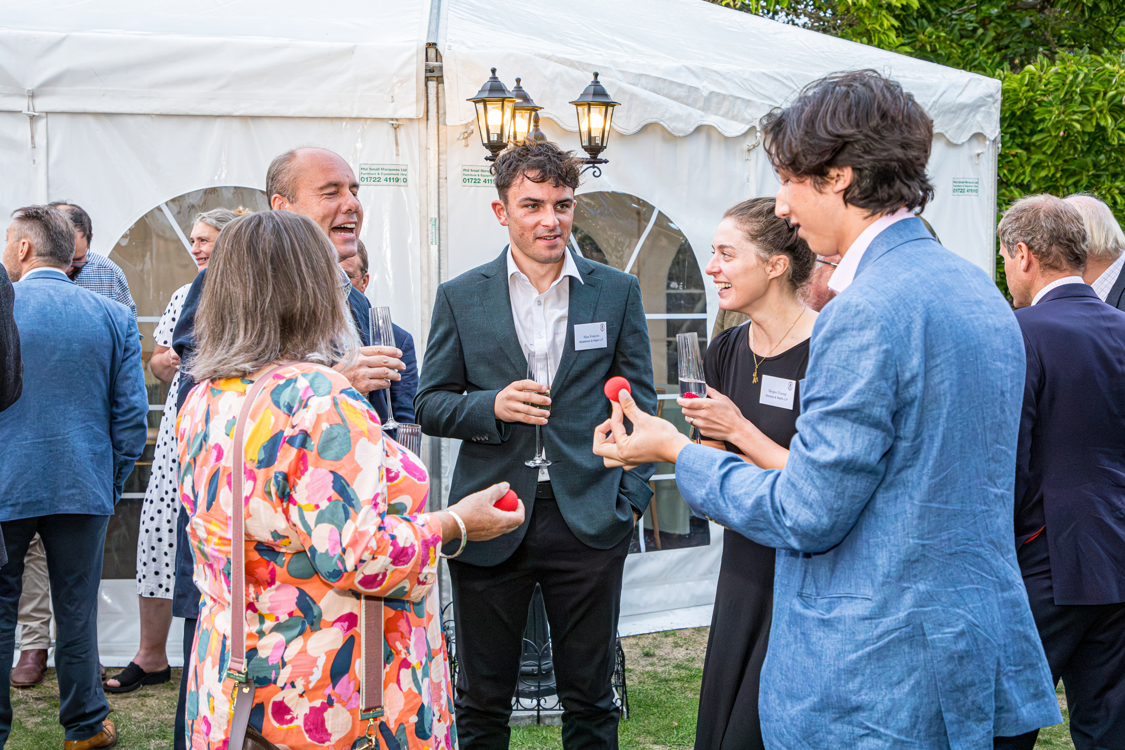 Guests enjoying close-up magic at the Wilsons summer party