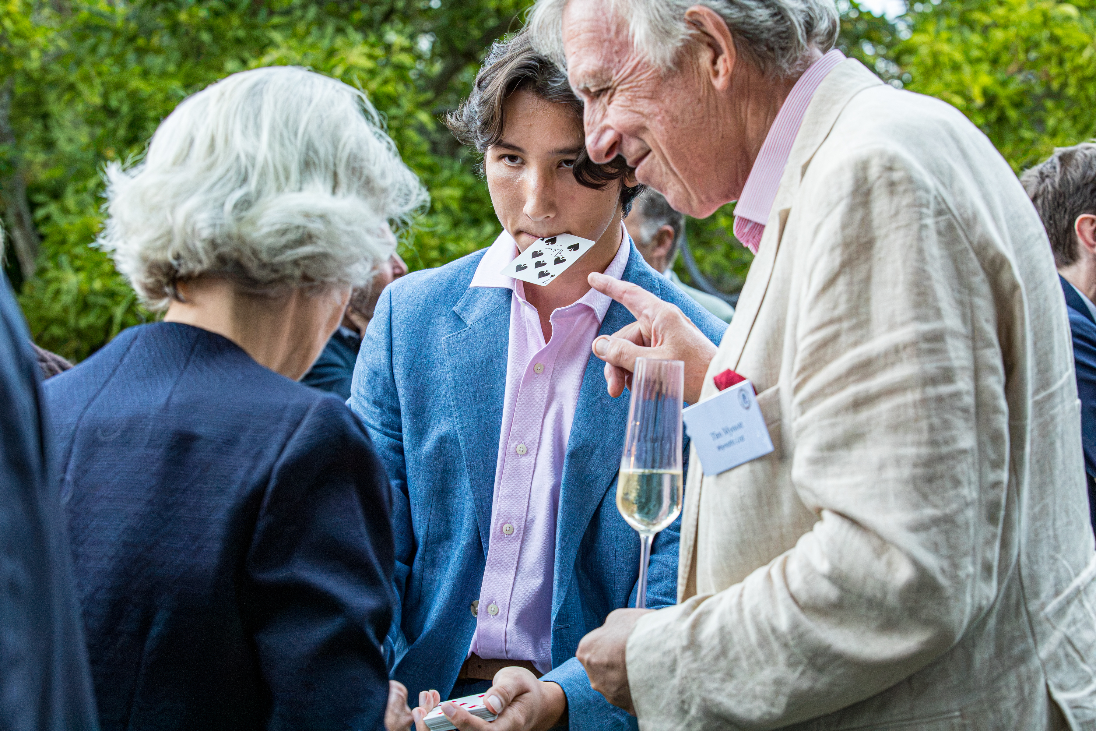 A guest reacting to Noah's close-up magic at a summer party
